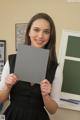 A woman in a black dress holding up a piece of paper.