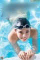 A woman in a swimming cap and goggles in a pool.