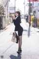 A woman in a business suit is walking down the street.