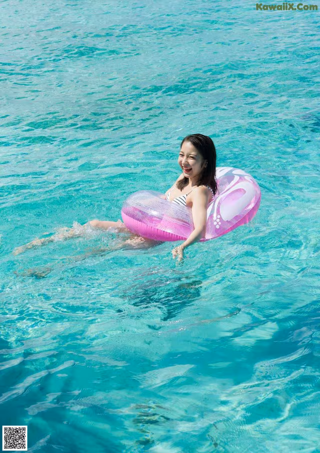A woman floating on an inflatable ring in the ocean.