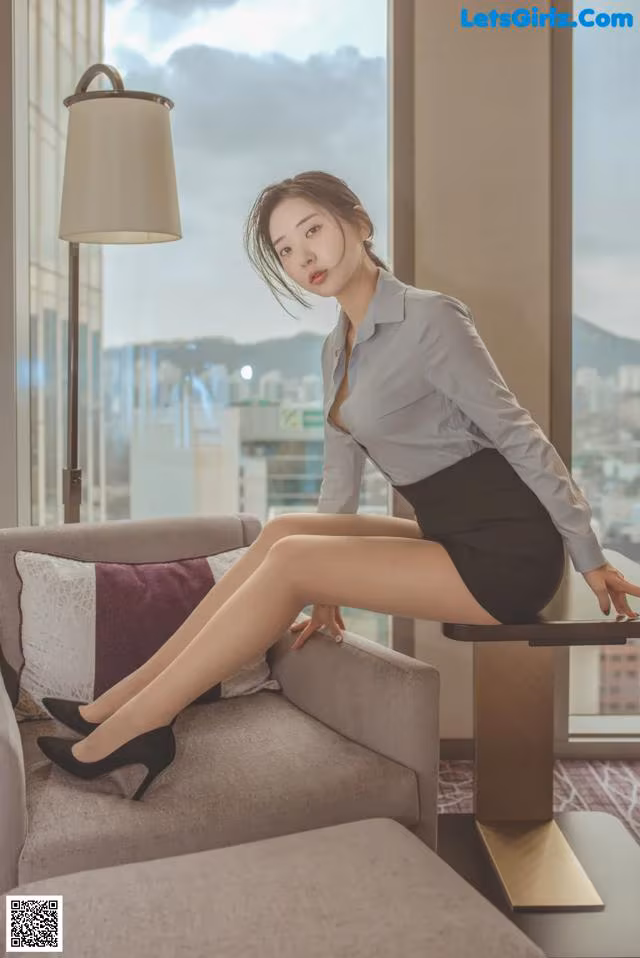 A woman sitting on a couch in a room.