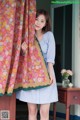 A woman standing in front of a window holding a scarf.