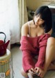 A woman sitting on the floor looking at her cell phone.