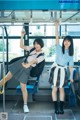 A couple of young women standing on top of a bus.