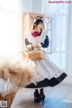 A woman in a maid outfit holding a basket of flowers.