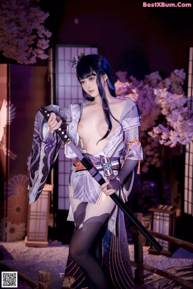 A woman in a kimono holding a samurai sword.