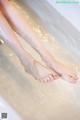 A woman's feet in a bathtub filled with water.