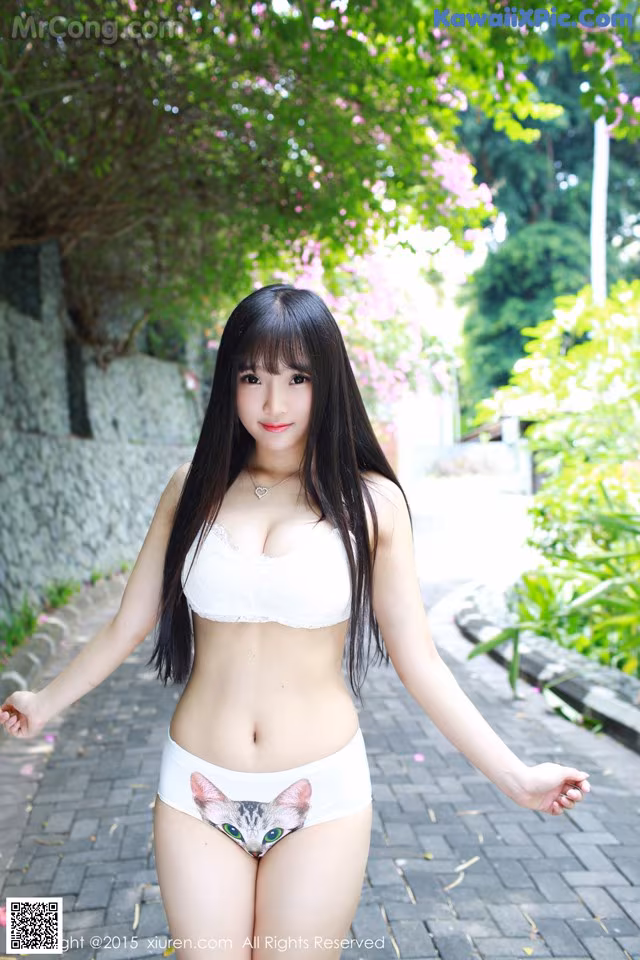 A woman in a white bikini with a cat on her underwear.